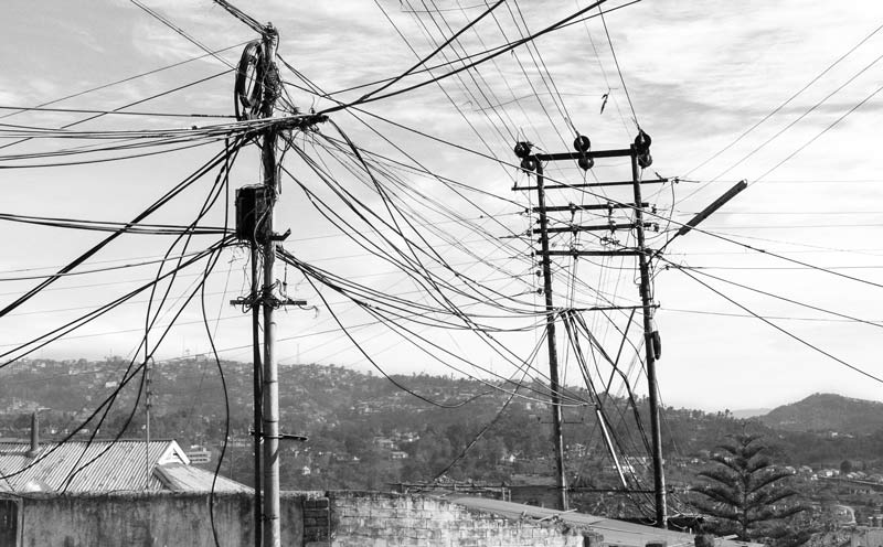 In the absence of proper supporting structures, water cables bringing water from hill springs and streams in Kohima, Nagaland hanging untidility between and over telephone and electricity poles